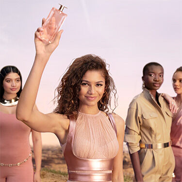 Model holding up the Idole perfume bottle
