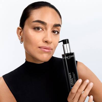 Model, welches den Genifique Ultimate Cleanser in der Hand halt