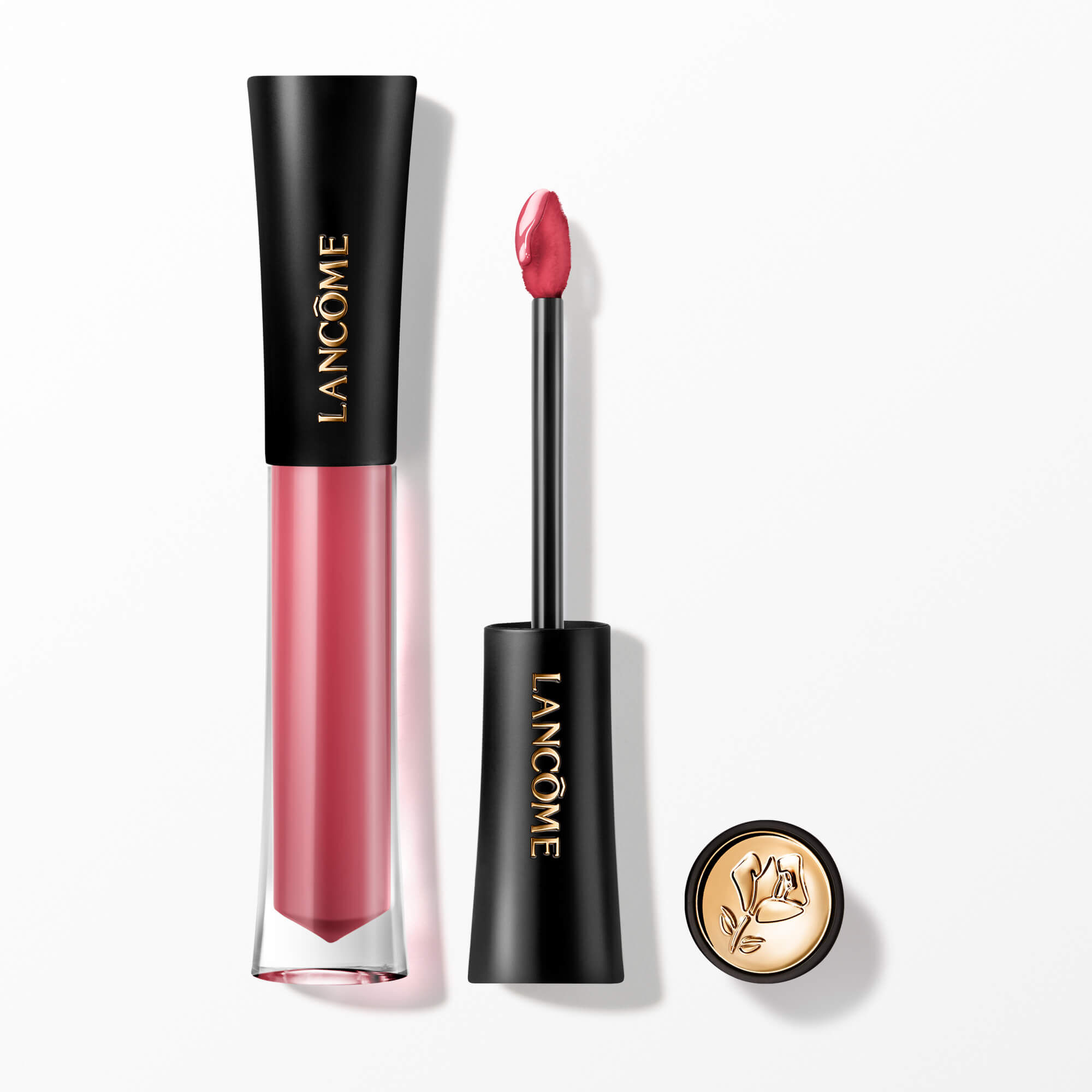 Ein Lancome L'Absolu Rouge Glaze Tintation flussiger Lippen-Tinting, prasentiert mit seinem Applikator-Zauberstab und einer goldakzentuierten Kappe mit der ikonischen Lancome-Rose.