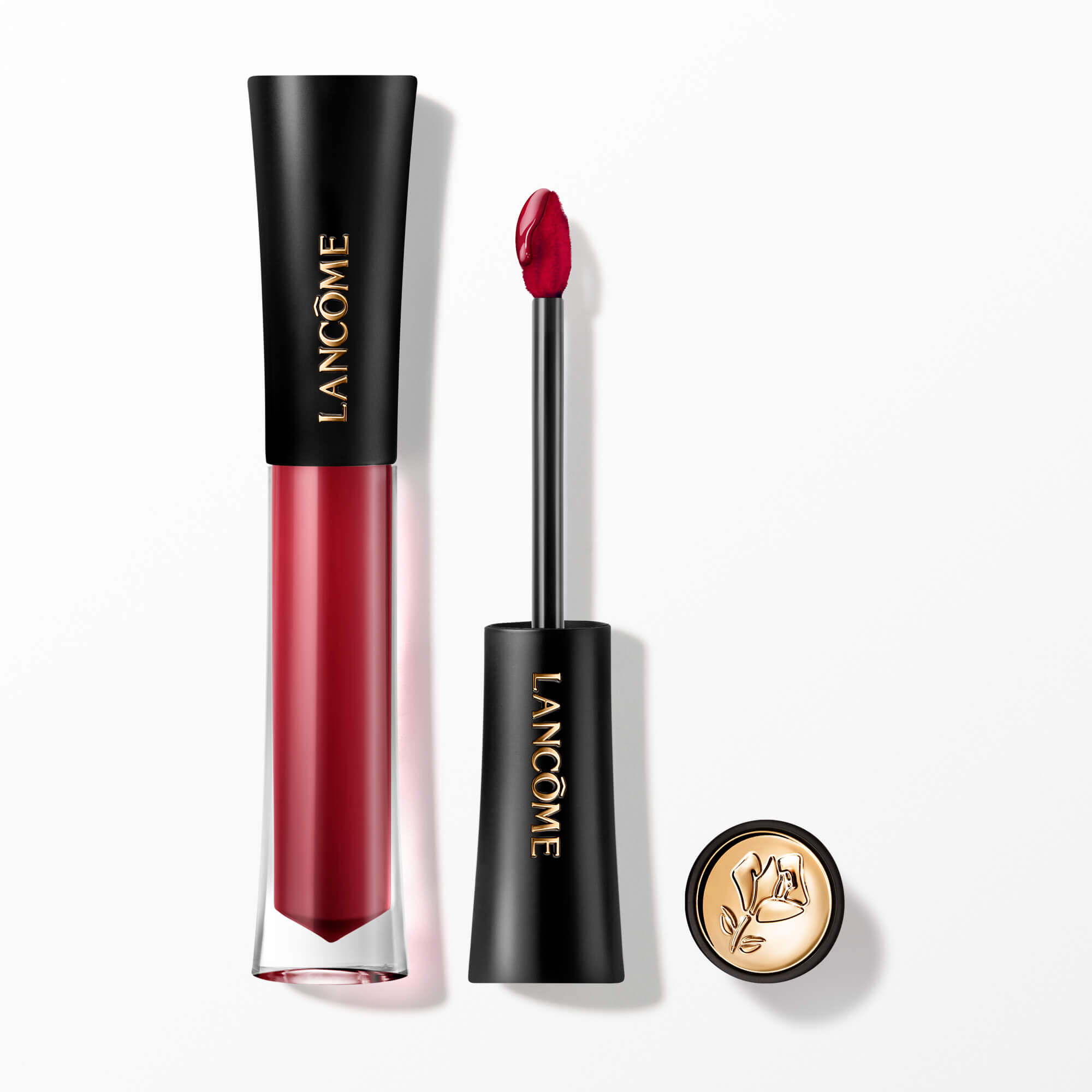 Ein Lancome L'Absolu Rouge Glaze Tintation flussiger Lippen-Tinting, prasentiert mit seinem Applikator-Zauberstab und einer goldakzentuierten Kappe mit der ikonischen Lancome-Rose.