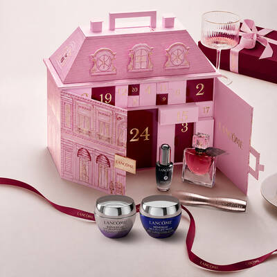 Ein geoffneter, pinkfarbener Lancome-Palast Adventskalender, prasentiert mit Beauty-Produkten und einer roten Schleife.