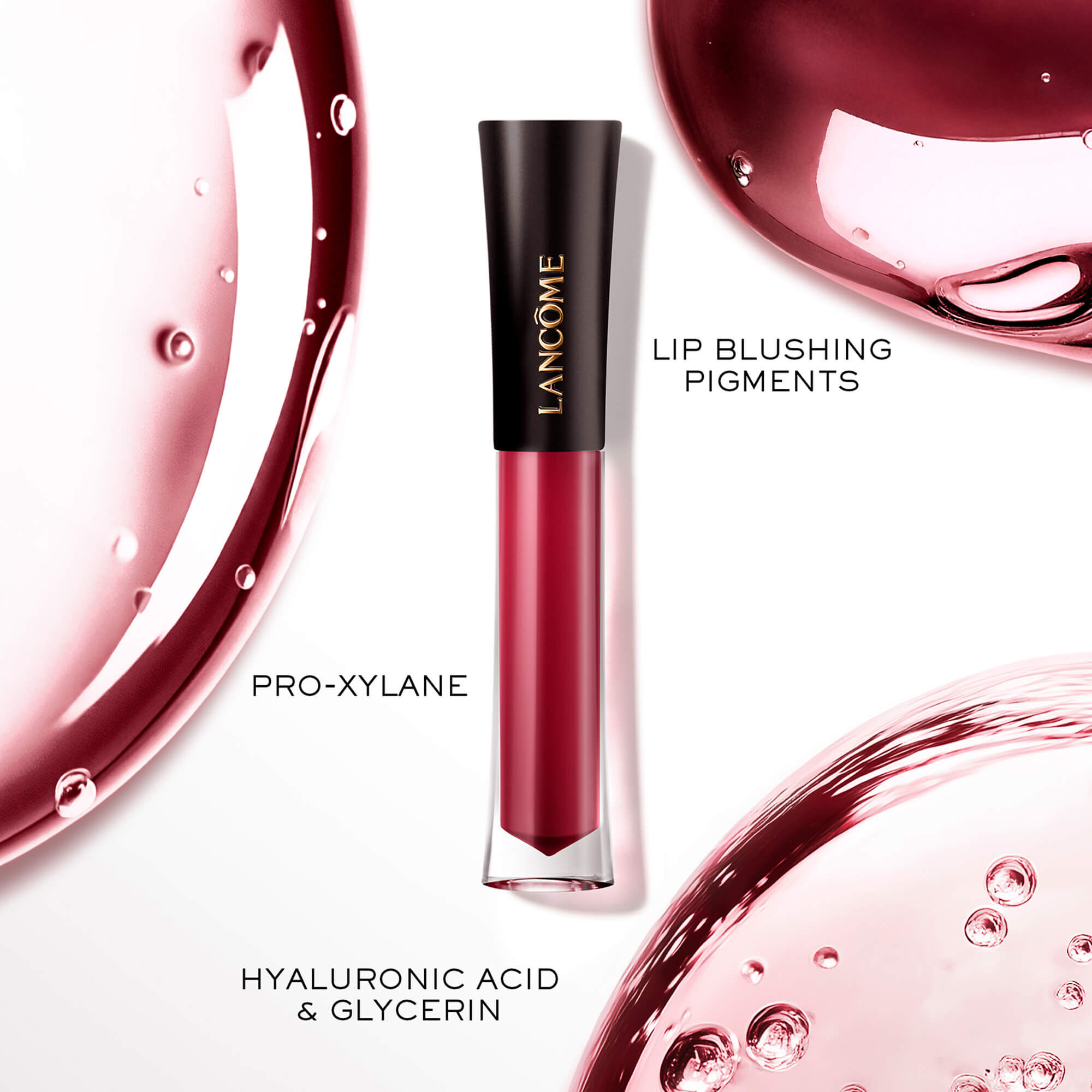Eine Lancome L'Absolu Rouge Glaze Tintation flussige Lippenfarbe, prasentiert zusammen mit kunstlerischen Glosstropfen, die die wichtigsten Inhaltsstoffe hervorhebt: Pro-Xylane, Lip Blushing Pigments und Hyaluronsaure & Glycerin.