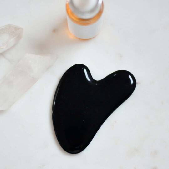 Ein schwarzes Gua Sha-Stein 