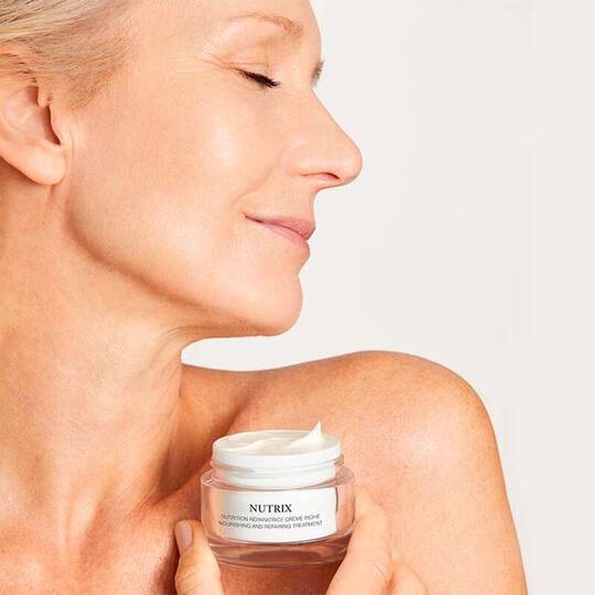 Frau Cremet sich Wange ein