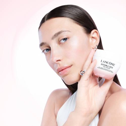 Eine Frau nutzt ein Produkt mit Vitamin E von Lancome fur glattere und strahlendere Haut