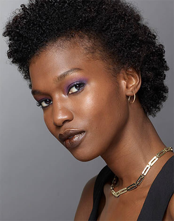 Eine Frau mit dunklen Haaren und einer leicht gelben oder pfirsichfarbenen Haut.