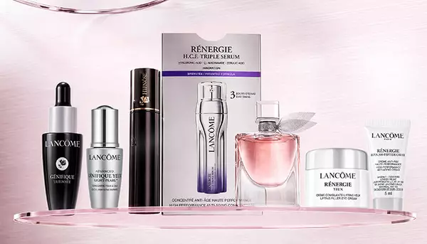 Lancome Pflegeprodukte und Parfum: Genifique Ultimate, Renergie H.P.N. 300-Peptide Cream und ein rosafarbenes Parfum auf einem hellen, glanzenden Hintergrund.