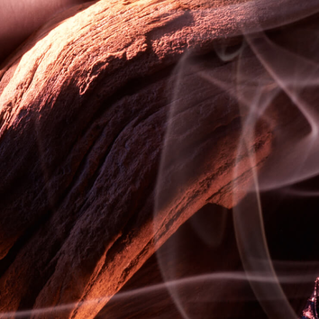 Detailaufnahme von verwittertem Holz mit sanften Rauchschwaden im Hintergrund, die eine mystische Atmosphare schaffen.
