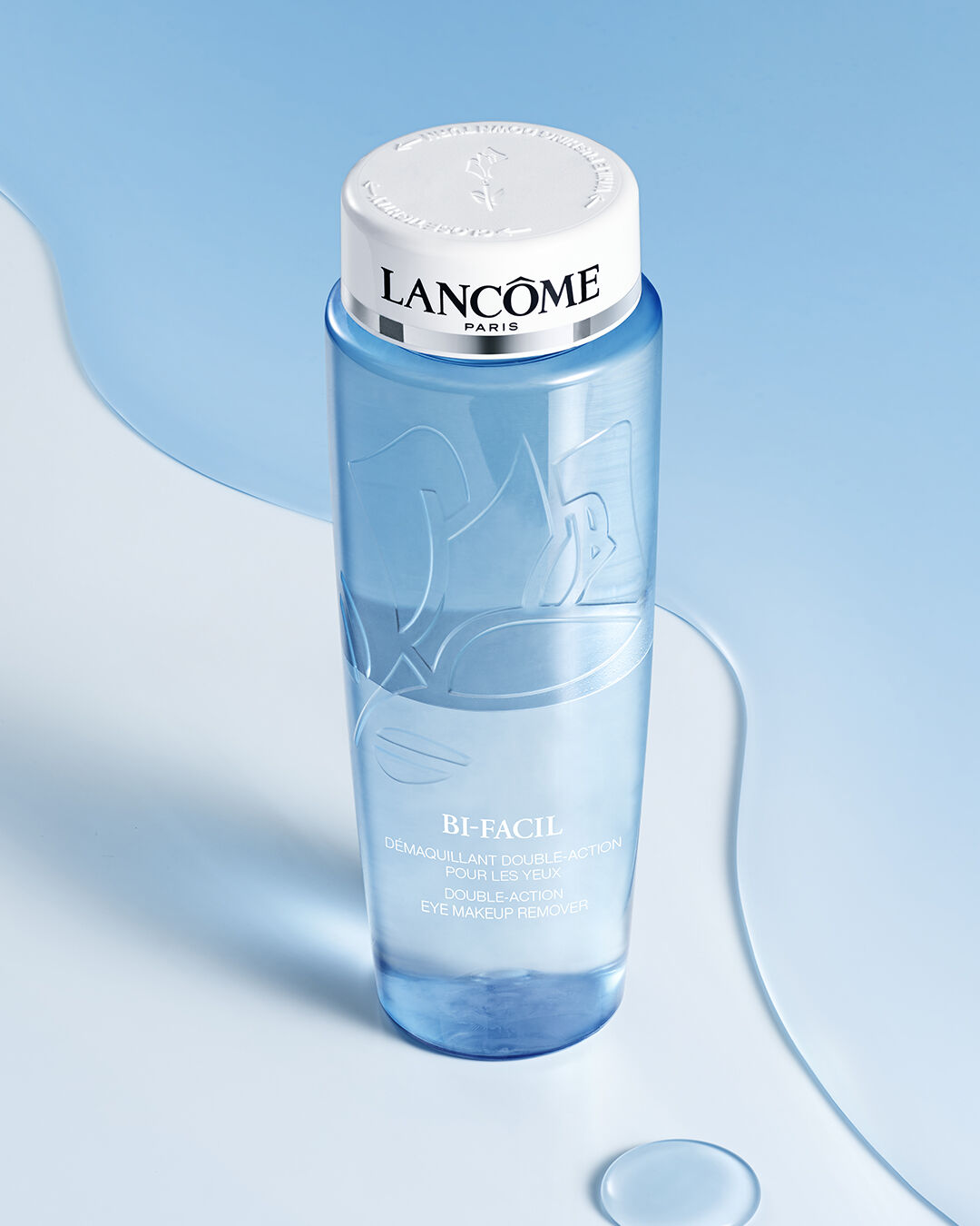 Eine Flasche mit dem Augen-Make-up-Entferner "Bi-Facil" von Lancome auf einem blauen Hintergrund.