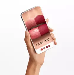 Eine Hand halt ein Smartphone, auf dem verschiedene Lippenstiftfarben von Lancome angezeigt werden.