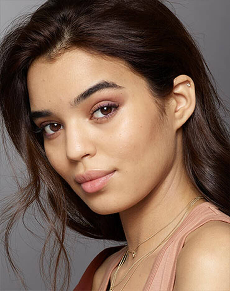 Eine Frau mit braunen Haaren und braunen Augen und einem neutralen Hautton.