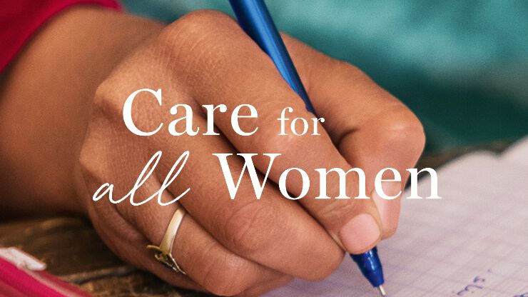 Eine Hand halt einen Stift und schreibt, auf dem Bild steht Care for all Women