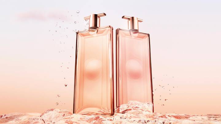 Zwei elegante Parfumflaschen stehen uber Wassertropfen vor einem sanften, pastelartigen Hintergrund.
