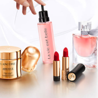 Nahaufnahme von Luxus-Beautyprodukten: Lippenstifte, Parfum und eine Hautcreme auf hellem Hintergrund.