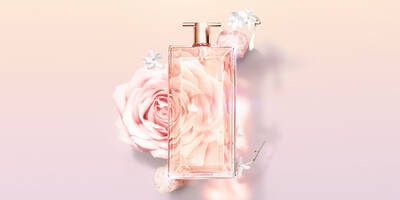 Parfum Flakon, im Hintergrund eine rosa Rose