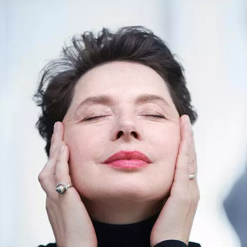 Die Schauspielerin Isabella Rossellini hat ihre Augen geschlossen, halt ihr Gesicht entspannt mit beiden Handen und lachelt leicht