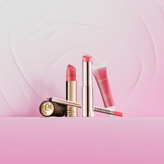 Eine Kollektion von Lancome Make-up-Produkten, darunter eine Lidschattenpalette, ein Kompaktpuder und ein roter Lippenstift, alle in eleganter rosa-goldener Verpackung.