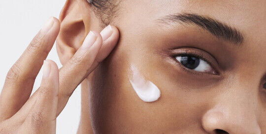 Frau, die sich Augencreme auftragt