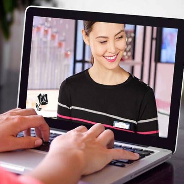Eine Frau lachelt auf einem Laptop Display und erhalt eine Experten-Beratung