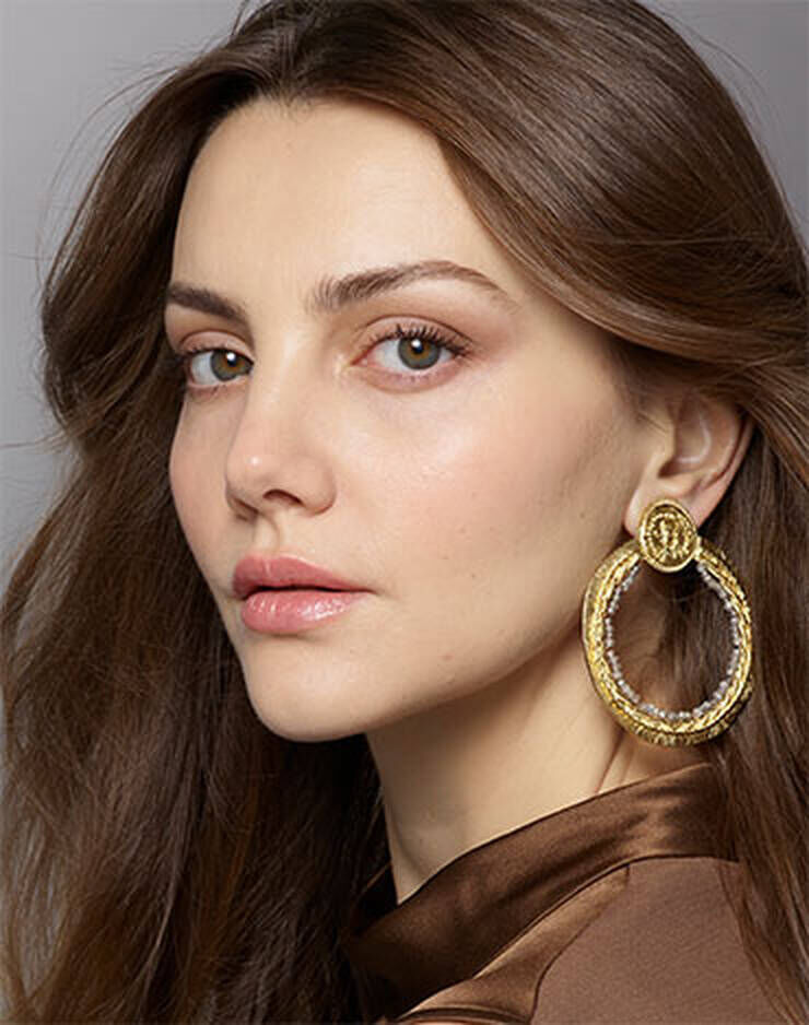 Eine Frau mit hellbraunen Augen und hellbraunen Haaren und einem leichten rosa, roten oder blaulichen Hautton