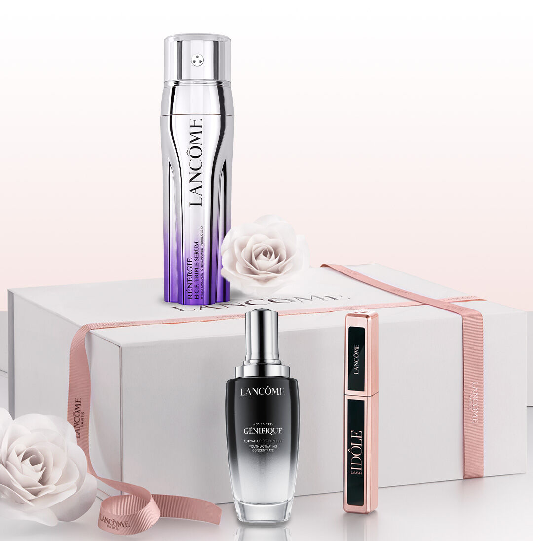 Eine stilvolle Geschenkbox mit Lancome-Produkten: einer Anti-Aging-Lotion, einem Serum und einer Mascara, umgeben von zarten Rosen.