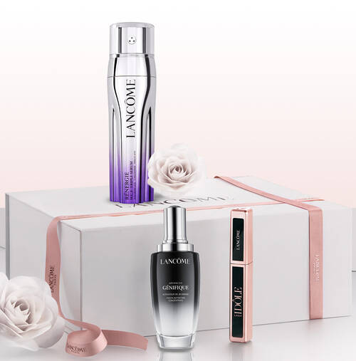 Eine stilvolle Geschenkbox mit Lancome-Produkten: einer Anti-Aging-Lotion, einem Serum und einer Mascara, umgeben von zarten Rosen.