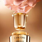 Flasche Lancome Absolue mit goldener Kappe und einer rosafarbenen Blute, die daruber schwebt. Elegantes, luxurioses Design.