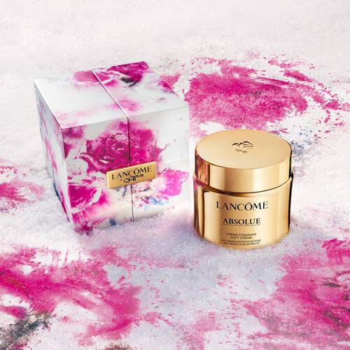 Luxuriose Lancome Absolue Gesichtscreme in goldener Dose, prasentiert in einer stilvollen Verpackung mit buntem Design.