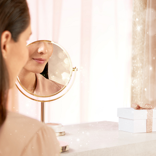 Frau sieht sich im Spiegel an