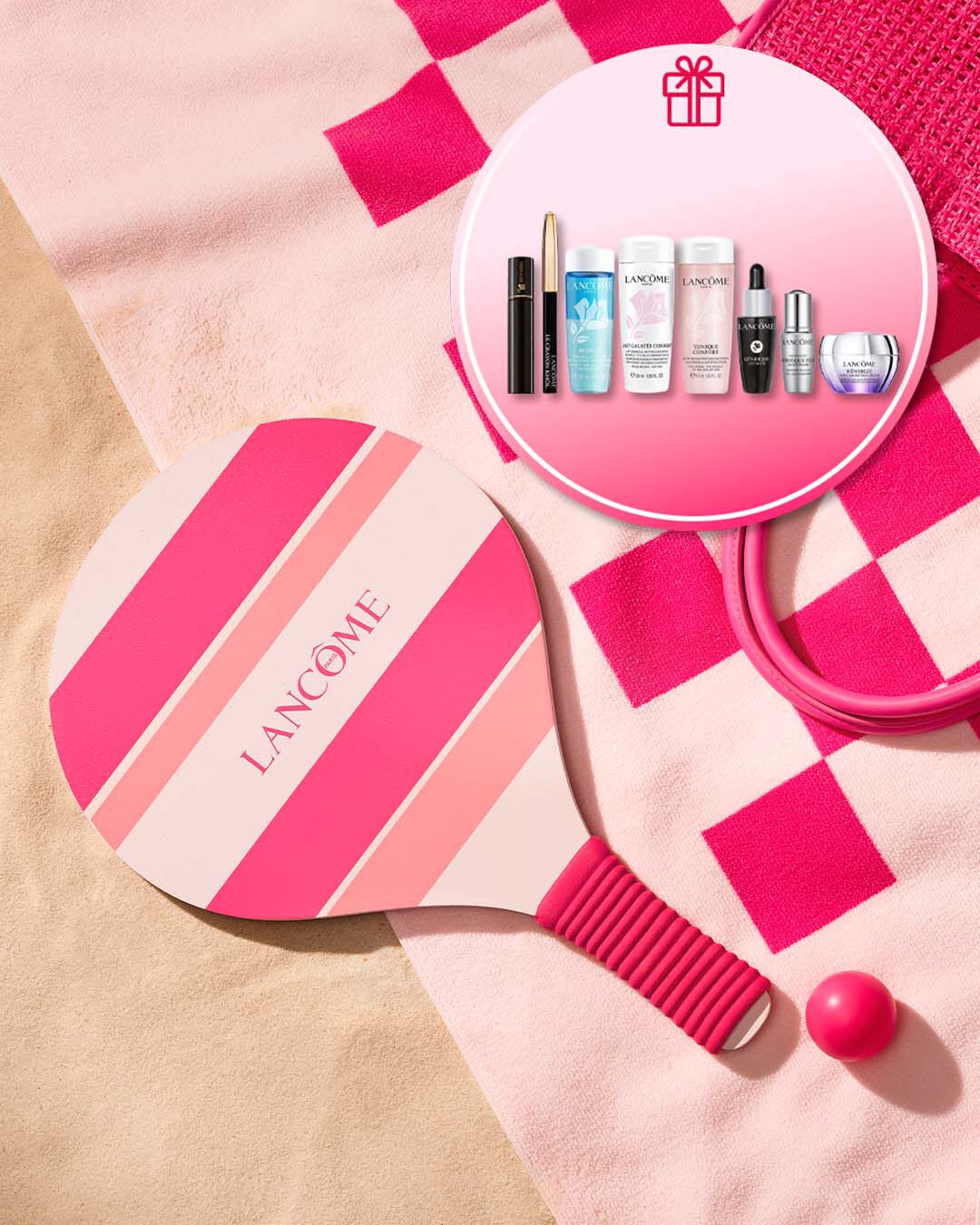 Lancome Sommer-Promotion-Banner am Strand mit einem rosa-pink gestreiften Strand-Tennisschlager und passendem Ball auf einem Handtuch im Sand. Ein runder Einleger oben rechts mit einem Geschenk-Symbol zeigt das exklusive Gratis-Geschenkset mit Lancome-Miniaturen, darunter Reinigungsprodukte wie Bi-Facil und Tonique Confort, ein Augenkajal, Mascara sowie Advanced Genifique und Renergie Pflegeprodukte.
