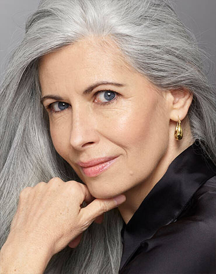 Eine Frau mit grauen Haaren und graulichen Augen und einem leicht gelben oder pfirsichfarbenen Hautton