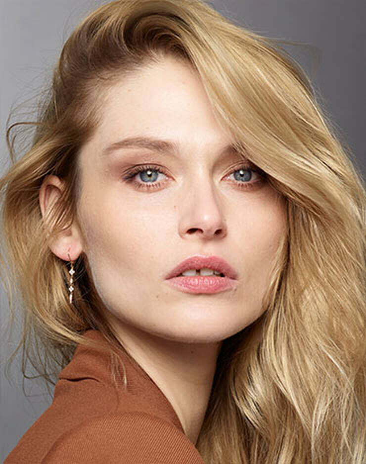 Eine Frau mit hellen Augen und hellen Haaren und einem neutralen Hautton.