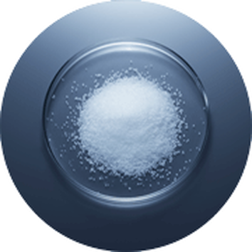 Weiße Kristallstruktur in einer Glasschale auf einem blauen Hintergrund. Wissenschaftliche und chemische Asthetik.