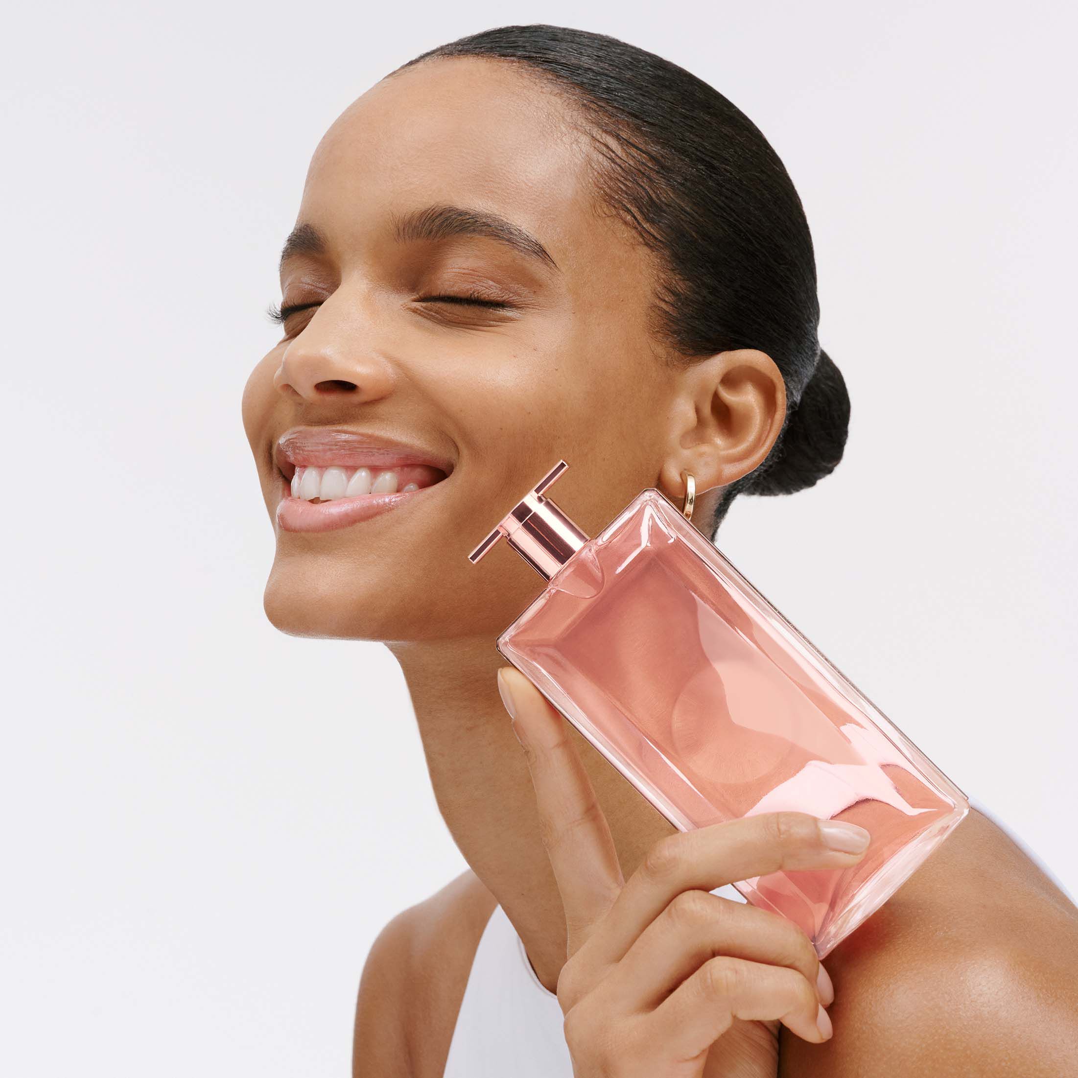 Nahaufnahme einer Frau mit Parfum-Flasche in der Hand