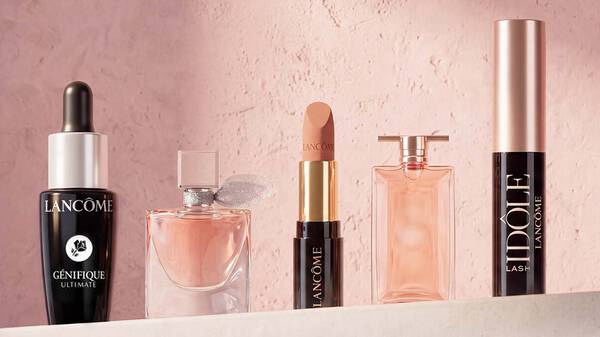 Hande halten Lancome Genifique Seren neben einem Geschenk-Symbol mit einem Aktions-Set auf der rechten Seite.