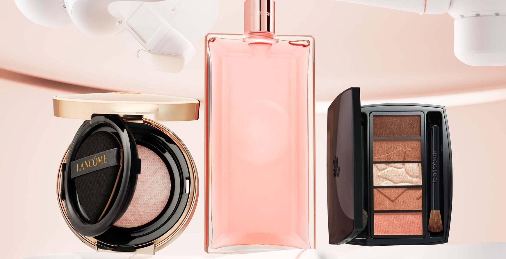 Alt-Text: Drei Kosmetikprodukte - ein Blush, ein Parfum und ein Lidschatten - stehen auf einer futuristischen, robotischen Halterung.