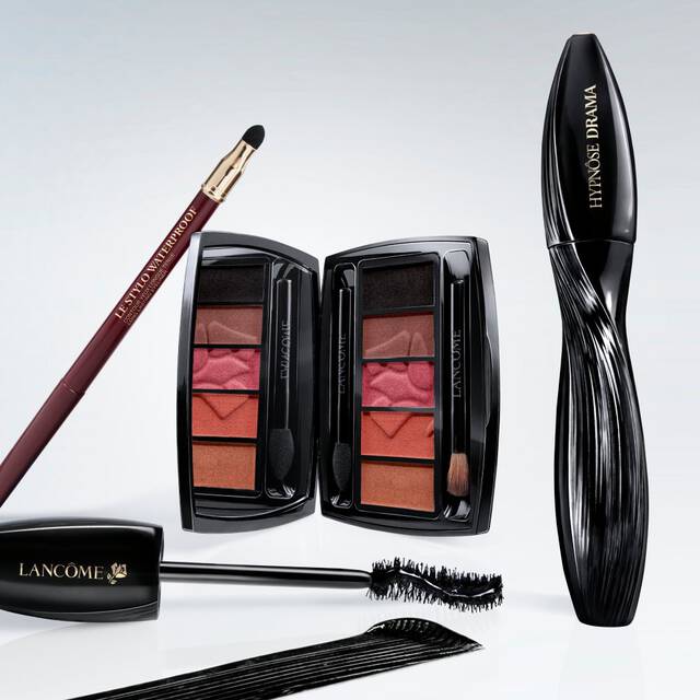 Eine Anordnung von Schminkprodukten, darunter Lidschattenpaletten, Lippenstift und Mascara in eleganten schwarzen Verpackungen.