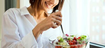 Eine Dame beim Salat essen.