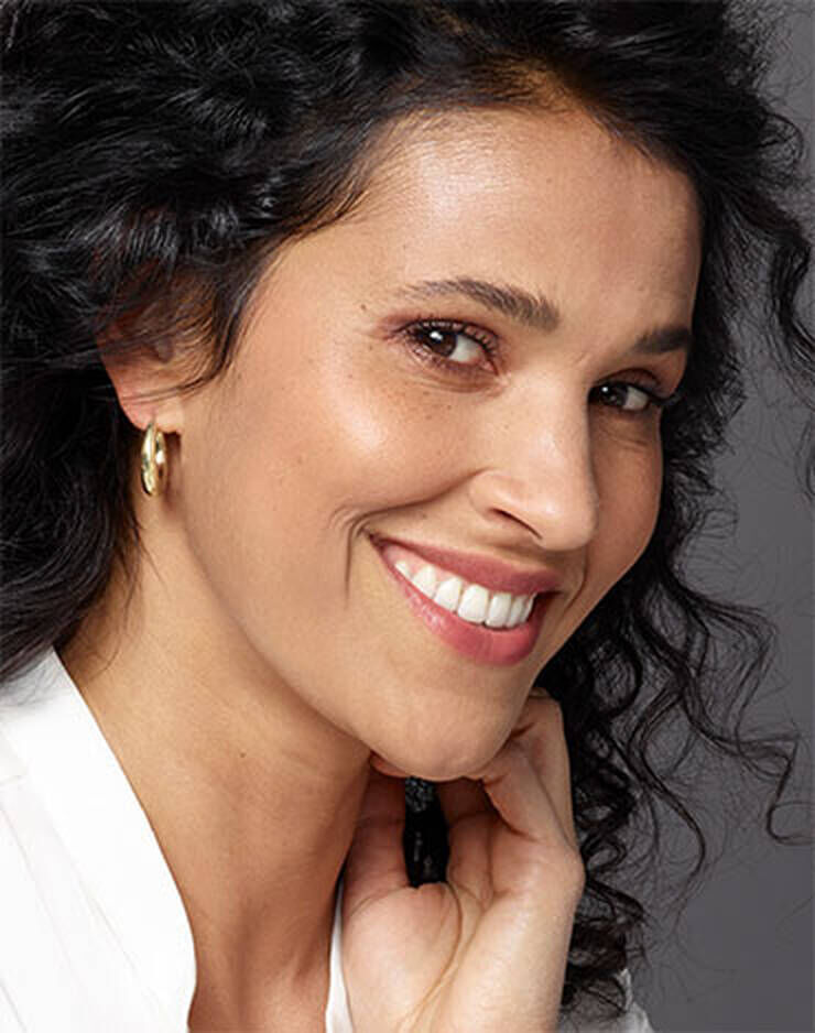 Eine Frau mit braunen Augen und dunklen Haaren und einem leichten rosa, roten oder blaulichen Hautton