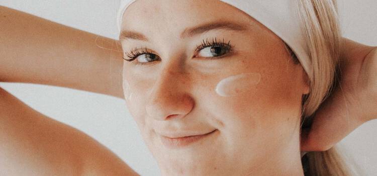 Frau mit Creme auf Wange