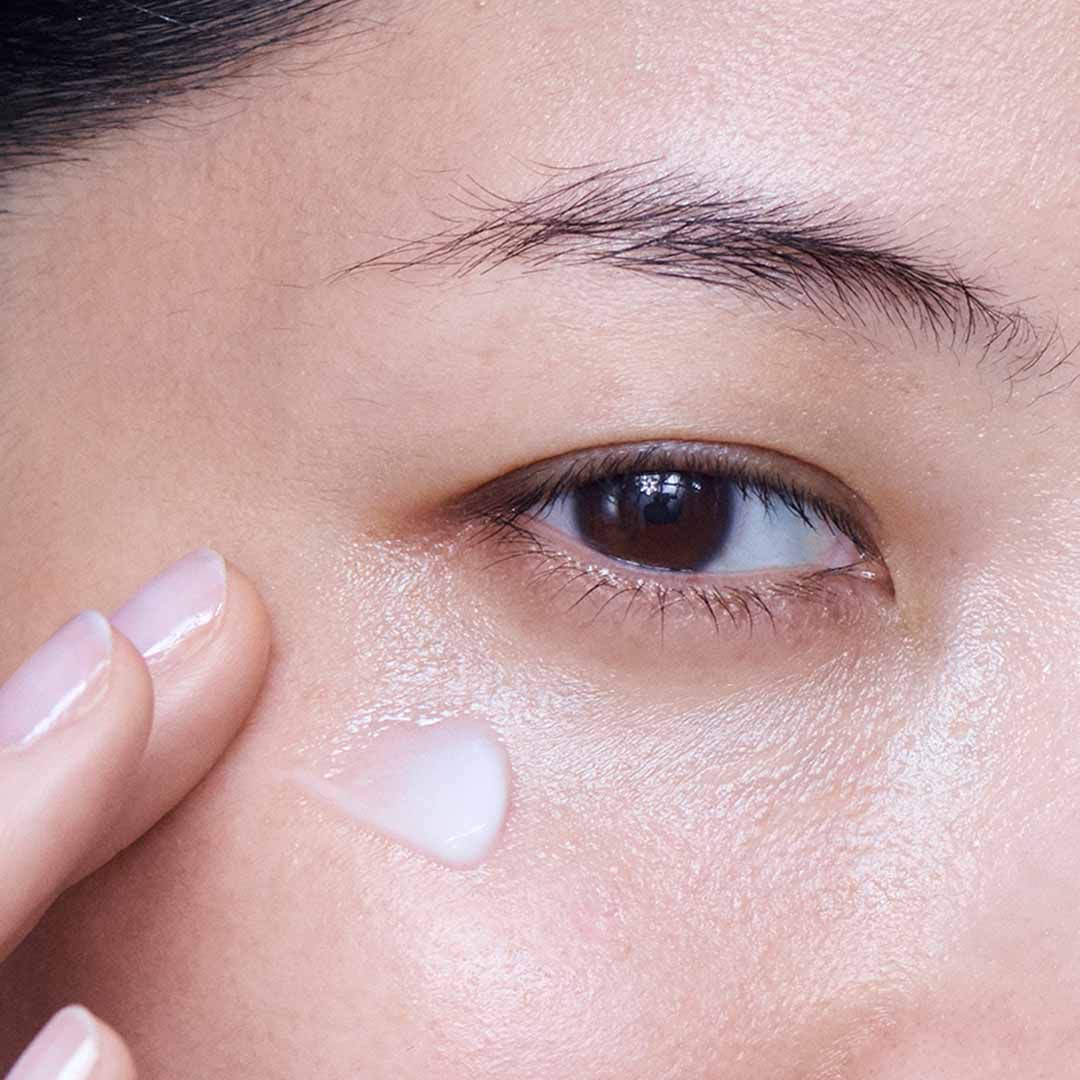 Frau schutzt ihre Haut mit Gesichtscreme