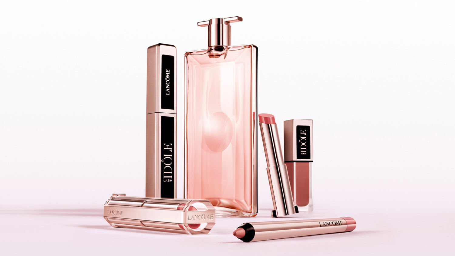 Ein Arrangement von Lancôme-Produkten, einschließlich Parfümflasche und Lippenstiften, auf einem neutralen Hintergrund.
