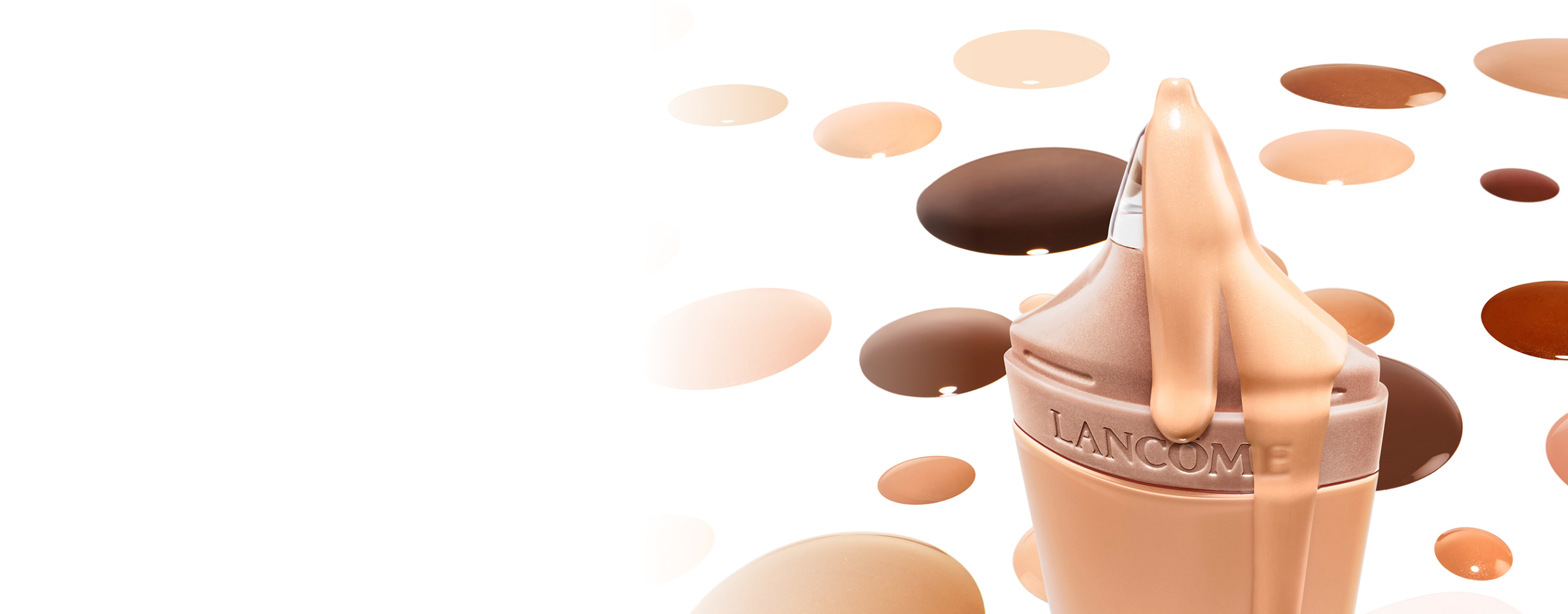 Ein Lancome Make-up-Flakon mit flüssiger Foundation, umgeben von verschiedenen Farbklecksen auf einem weißen Hintergrund.